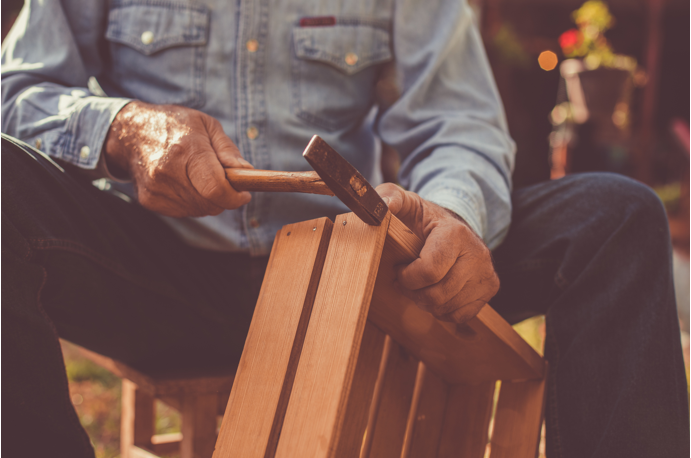 Man hammering nails into a wooden storage box
